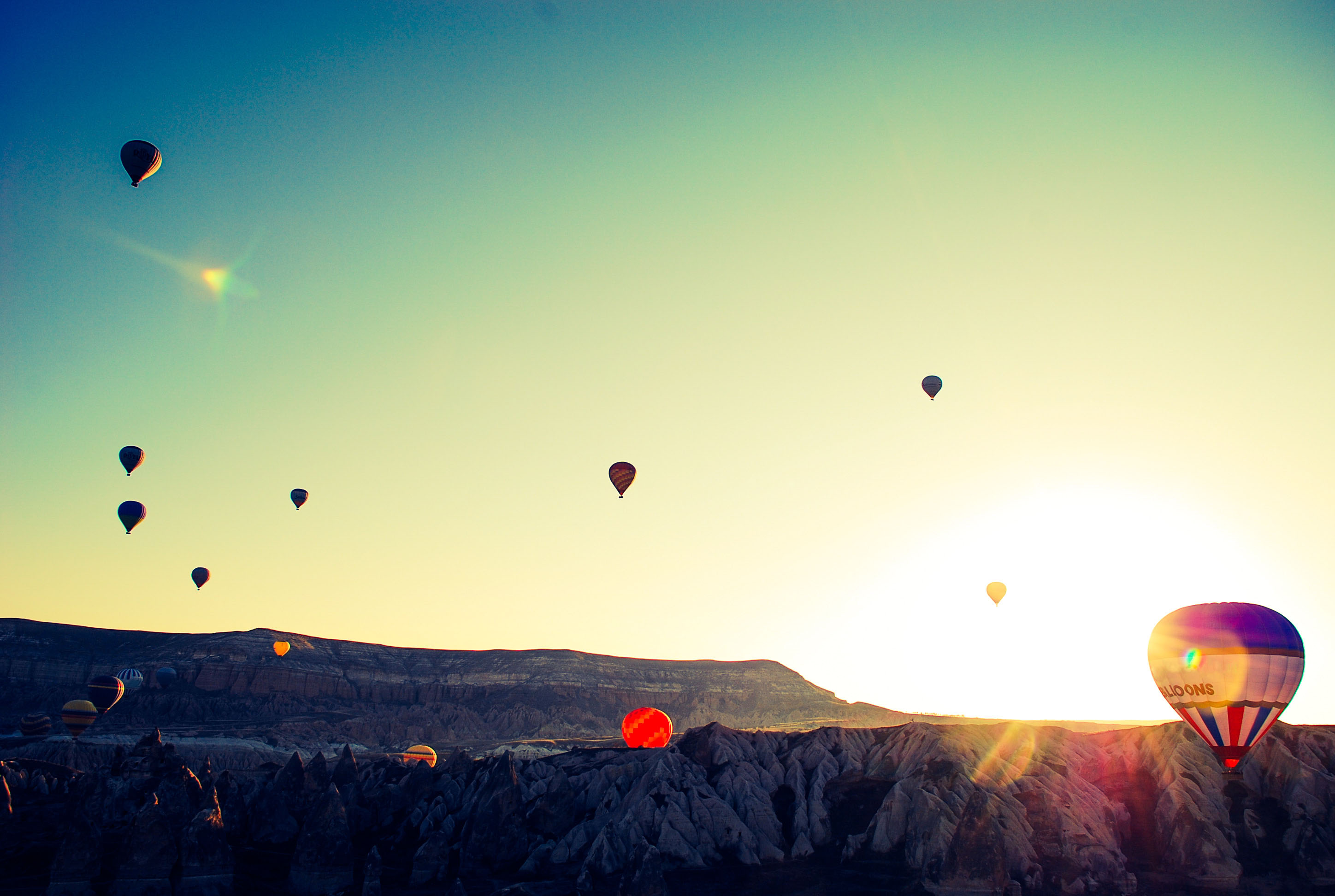 朝日の中飛ぶたくさんの気球